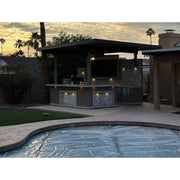 Kokomo Grills Best Outdoor Kitchen Bermuda BBQ Island with TV featuring pergola, built-in lighting, and sleek stone facade at dusk.