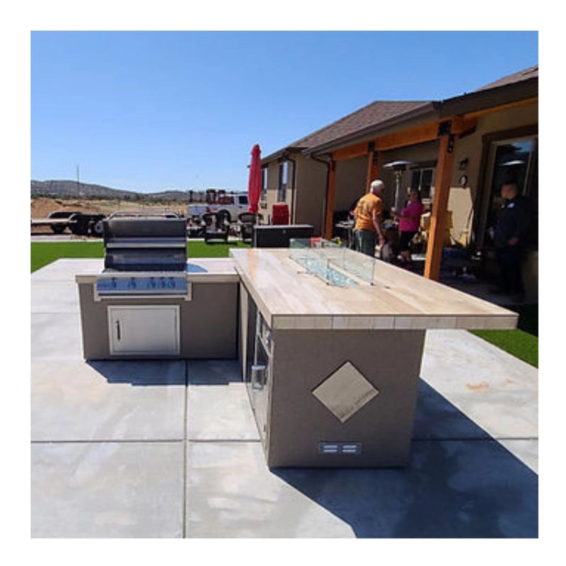 Kokomo Grills Baja/Fire L-Shaped BBQ Island with fire pit, 4-burner grill, outdoor refrigerator, and porcelain countertop.