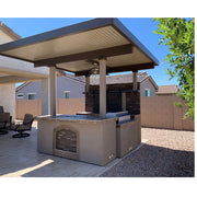 Kokomo Grills Barn Door TV Wall BBQ Island with 4 burner grill, stone arch accent, and covered pergola in beige tones.