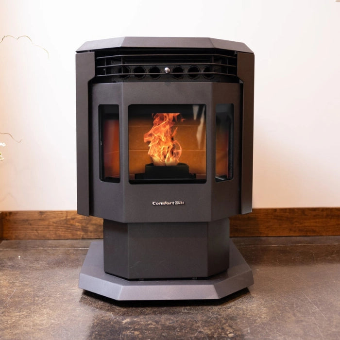 Black pellet stove with visible flames on a concrete floor.