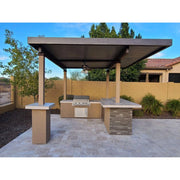 Kokomo Grills Aruba BBQ Island with 12' x 12' pergola, stucco finish, stone accents, 4-burner grill, and tile countertop.