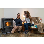 Man and woman sitting by a pellet stove in a cozy living room.