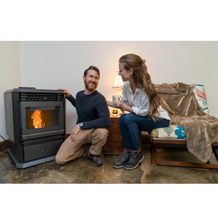 Man and woman sitting by a pellet stove in a cozy living room.