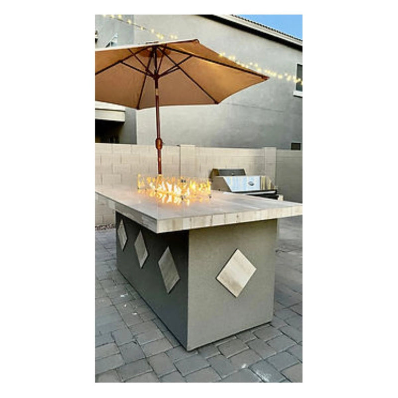 Kokomo Grills Baja/Fire L-Shaped BBQ Island with fire pit, porcelain countertop, galvanized steel frame, and beige umbrella.