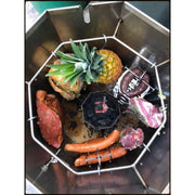 Grill Brothers Barrel Medium stainless steel barrel grill with hanging hooks cooking assorted meats and pineapple around charcoal tray.