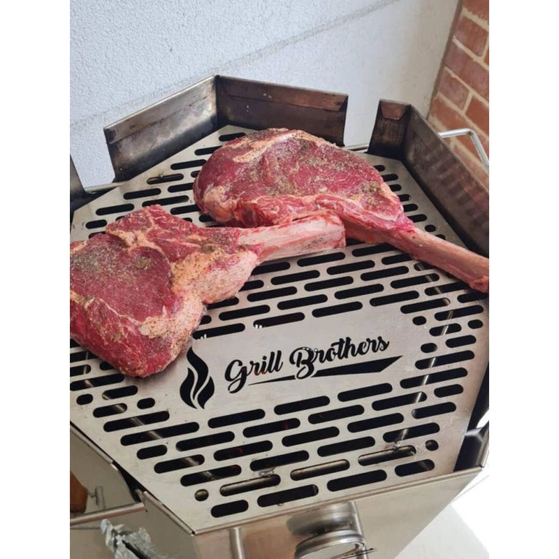 Grill Brothers Barrel Small stainless steel smoker grill with built-in thermometer and premium grilling surface cooking two seasoned steaks.