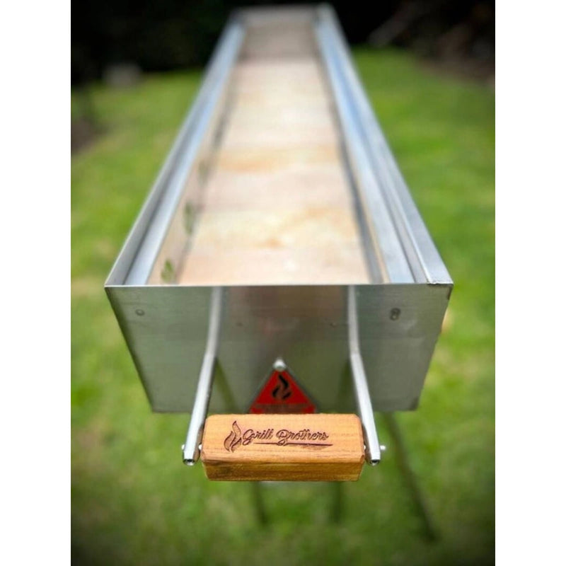 Grill Brothers Robatta stainless steel charcoal grill with wooden handle and refractory brick base for outdoor Japanese-style grilling.