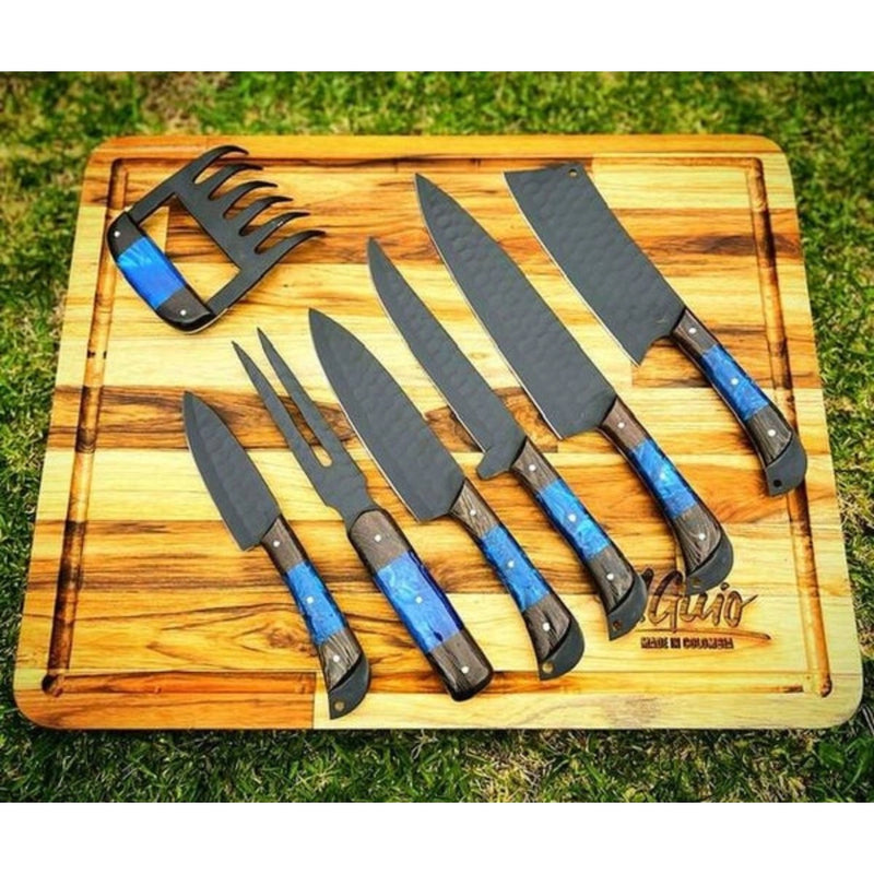 Grill Brothers SET KNIVES featuring high-carbon steel blades with blue and black ergonomic handles displayed on a wooden cutting board.