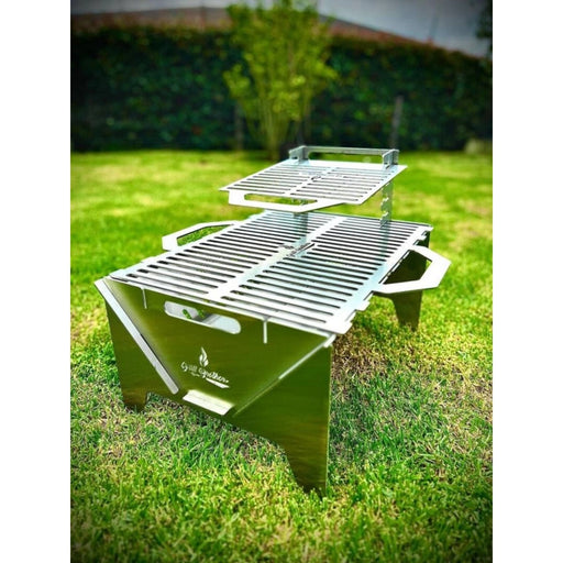 Grill Brothers TO GO Grill stainless steel portable BBQ with adjustable dual grilling heights and foldable handles for outdoor cooking.