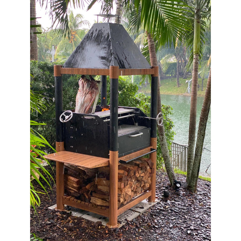 Tagwood BBQ The Beast Argentine Santa Maria Style wood fire gaucho grill with black steel, wood accents, peaked roof, and adjustable grates.