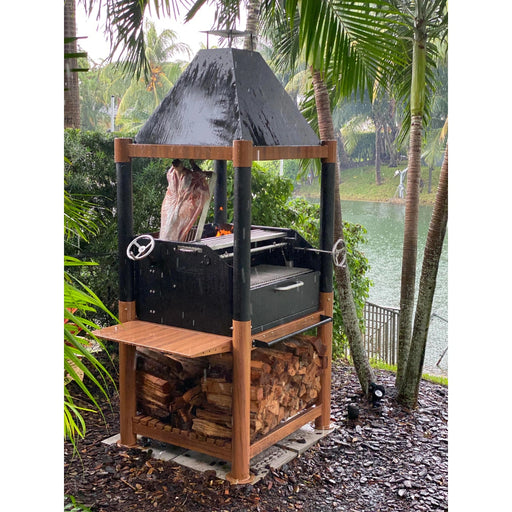 Tagwood BBQ The Beast Argentine Santa Maria Style wood fire gaucho grill with black steel, wood accents, peaked roof, and adjustable grates.