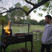 Tagwood BBQ Freestanding Argentine Santa Maria Wood Fire & Charcoal Gaucho Grill BBQ03SI in black steel with brasero firebox and adjustable grates.