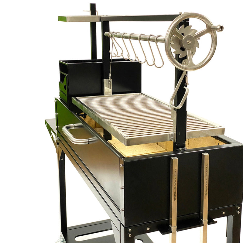 Tagwood BBQ Freestanding Argentine Santa Maria Grill with black steel body, stainless steel grates, and height-adjustable grilling wheel.
