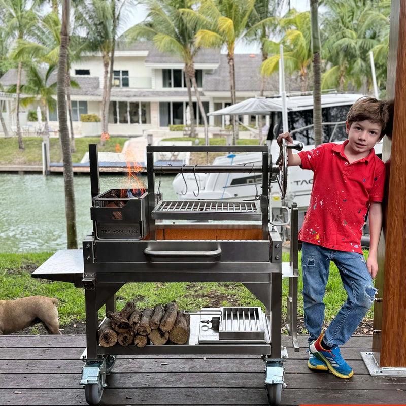 Tagwood BBQ Freestanding Mini Argentine Santa Maria Wood Fire & Charcoal Grill in stainless steel with brasero firebox and adjustable grates.
