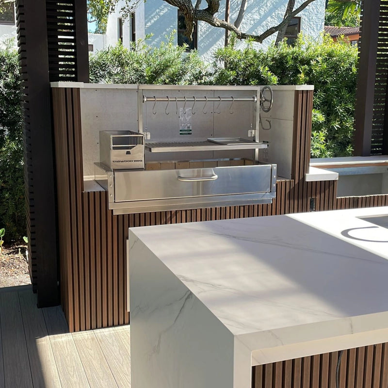 Tagwood BBQ Built-In Santa Maria Argentine wood fire grill in stainless steel with adjustable grates and gaucho-style brasero firebox.