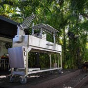 Tagwood BBQ Freestanding Argentine Santa Maria Grill BBQ06SS in stainless steel with height-adjustable grates and wheeled cart design.