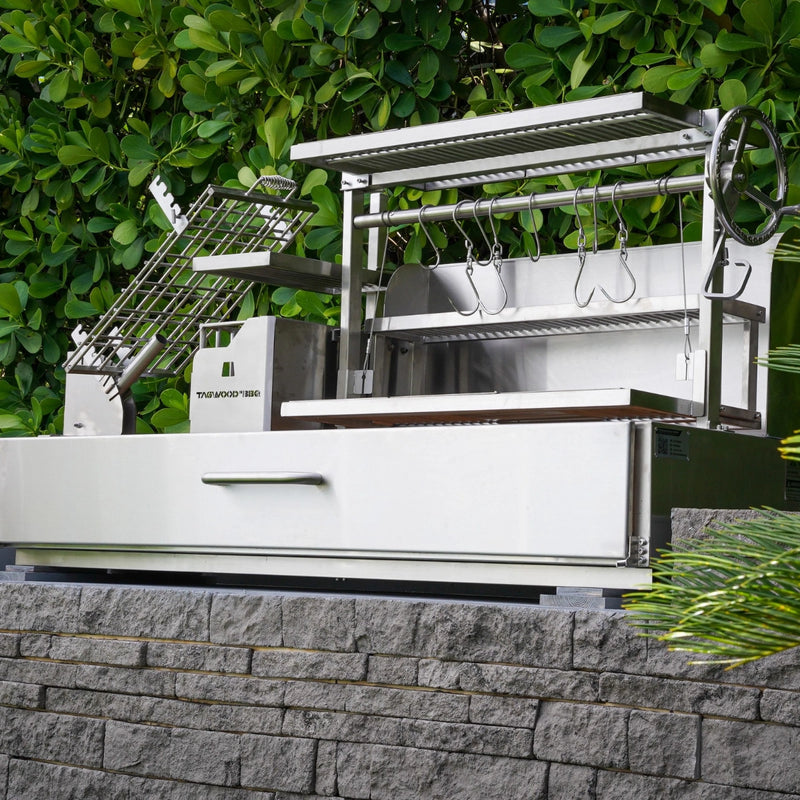 Tagwood BBQ Built-In Santa Maria Argentine Wood Fire & Charcoal Gaucho Grill with stainless steel, adjustable grates, and gaucho-style firebox.