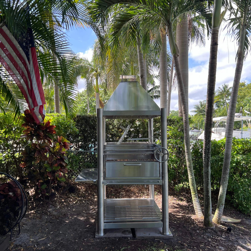 Tagwood BBQ Santa Maria Wood Fire & Charcoal Gaucho Grill BBQ12SS with 304 stainless steel, height-adjustable grates, and firebox outdoors.