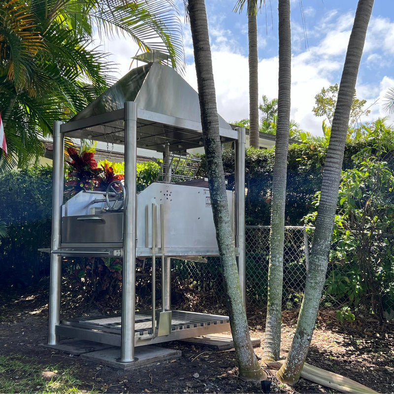 Tagwood BBQ Santa Maria Wood Fire & Charcoal Gaucho Grill BBQ12SS with stainless steel frame, adjustable grates, and brasero firebox outdoors.