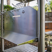 Tagwood BBQ Santa Maria Wood Fire & Charcoal Gaucho Grill BBQ12SS in stainless steel with height-adjustable grates and firebrick interior.