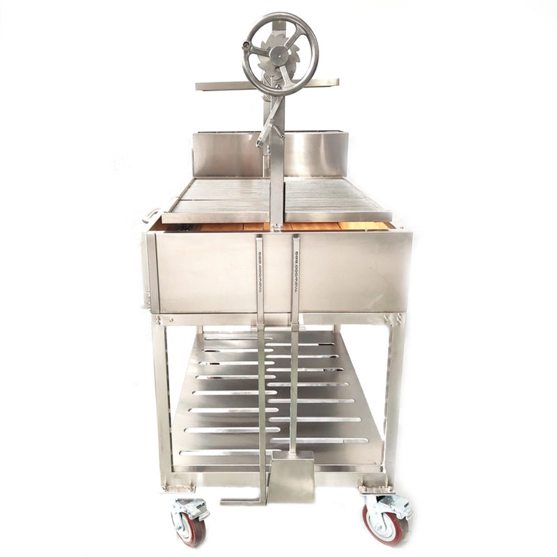 Tagwood BBQ XL Freestanding Argentine Santa Maria Grill in stainless steel with height-adjustable grates and wheeled base for large outdoor cooking.