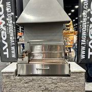 Tagwood BBQ XL Built-In Santa Maria Argentine Wood Fire & Charcoal Gaucho Grill in stainless steel with height-adjustable grates and peaked roof