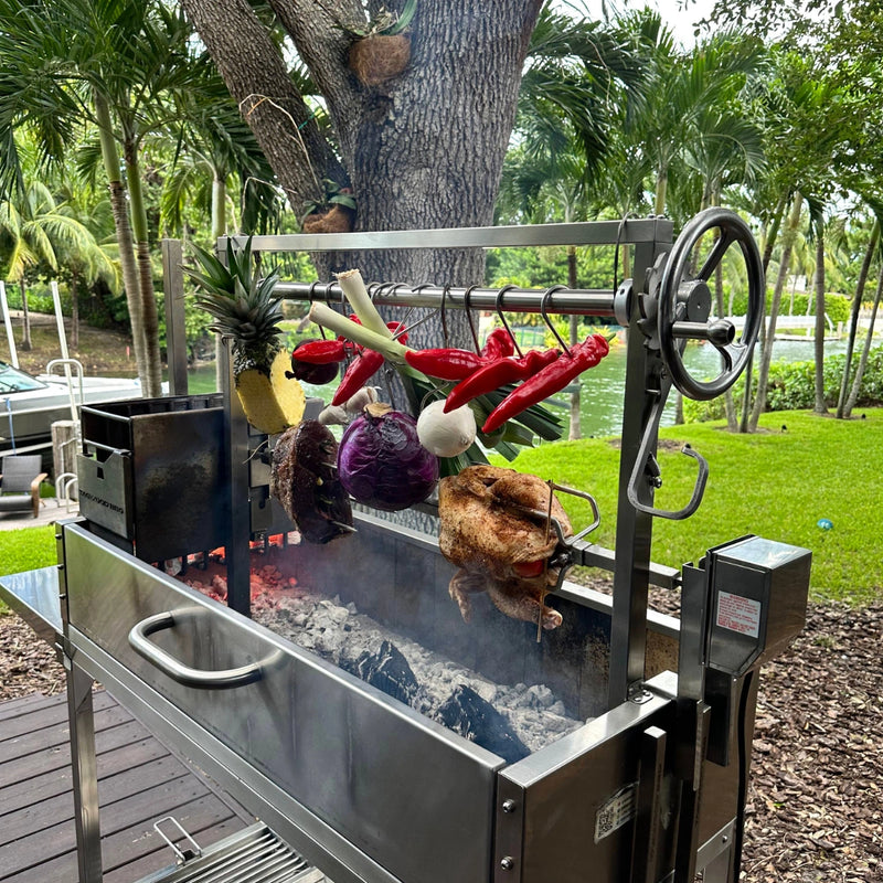 Tagwood BBQ Stainless Steel Rotisserie Kit - BBQ50SS with 40-inch stainless steel frame, motor, forks, and clamps roasting meats and vegetables outdoors.