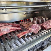 Tagwood BBQ V-Shape grill BBQ78SS with durable 304 stainless steel, V-shaped grate, front grease collector, on a grill with meats.