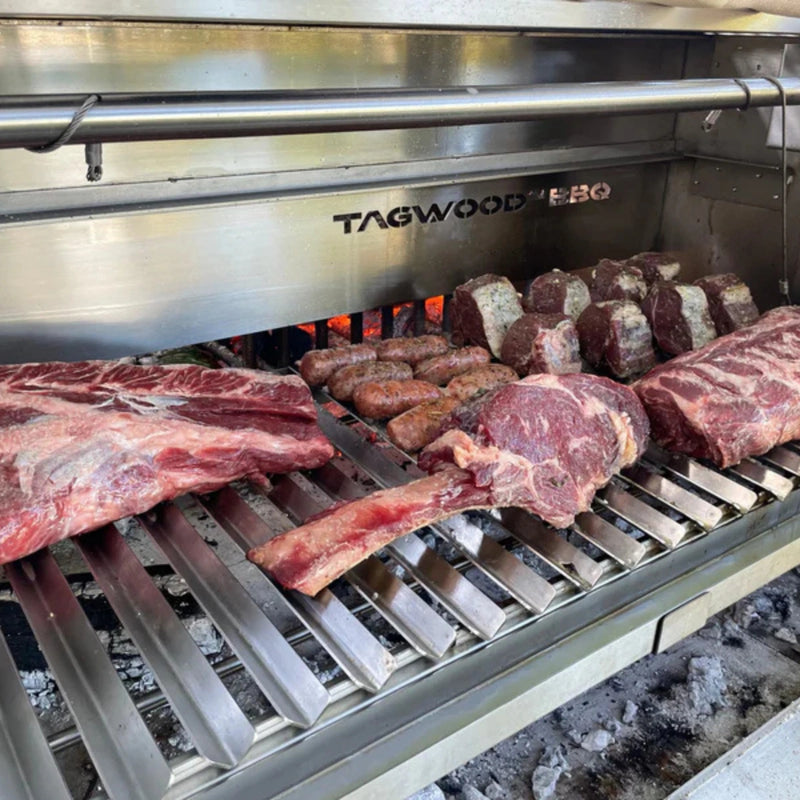 Tagwood BBQ V-Shape grill BBQ78SS with durable 304 stainless steel, V-shaped grate, front grease collector, on a grill with meats.