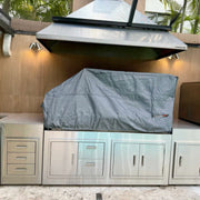 Tagwood BBQ BBQ28SS Cover in gray vinyl with adjustable drawstring, vent windows, and velvet liner protecting a built-in grill.