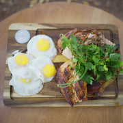 Tagwood BBQ Edge-Grain Cutting & Carving Board TAWO04 in Acacia wood with juice groove and hand grips, holding eggs and roasted meat.