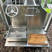 Tagwood BBQ Edge-Grain Cutting & Carving Board TAWO04 in durable Acacia wood with juice groove and hand grips beside stainless steel grill.