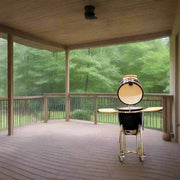 Barbecue grill on a wooden deck with a view of trees