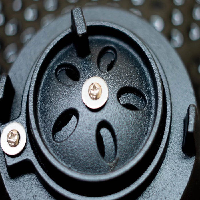 Close-up of a black mechanical component with screws on a metallic background