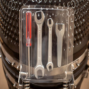 Set of wrenches and a screwdriver in a clear plastic package on a motorcycle engine.