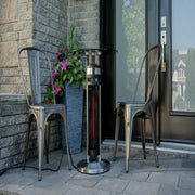 Outdoor patio scene with two chairs, a heater, and a potted plant on a stone patio.