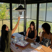 Three women sitting at a table with a scenic view outside