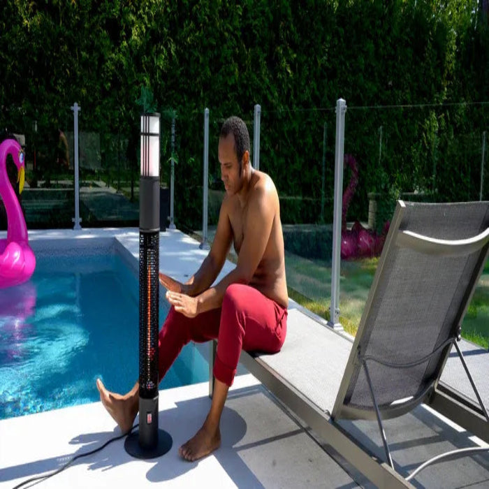 Man sitting by a pool with a patio heater, surrounded by pool toys.