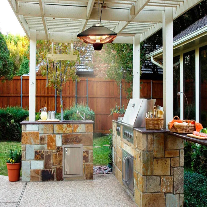 Outdoor kitchen with stone countertop and grill area under a covered patio.