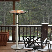 Outdoor patio heater on a snowy deck with furniture and potted plant.