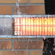 Close-up of a heating element with water dripping on a brick wall background