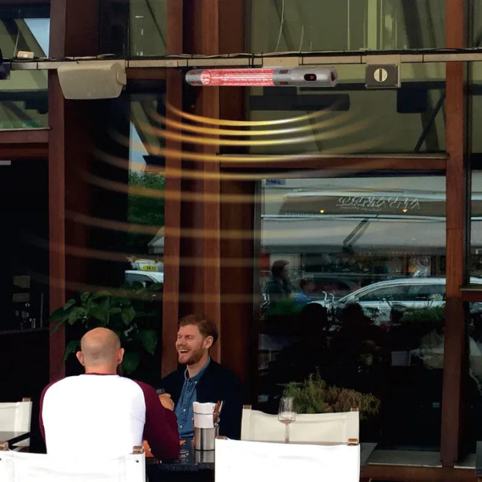 Two men sitting at a table outside a building with a reflection of cars and people.
