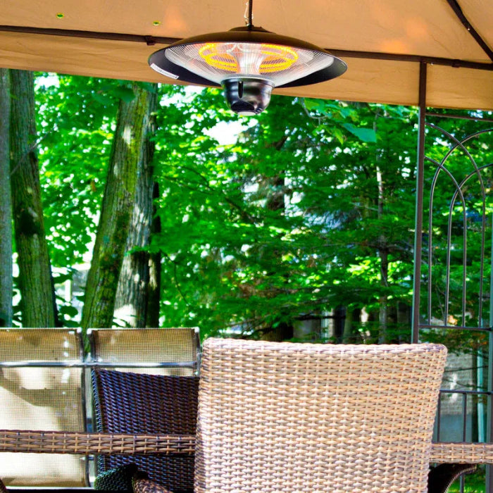 Outdoor patio heater hanging above a table and chairs with trees in the background
