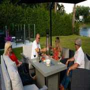 Group of people sitting around a patio table in a garden setting