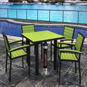 Outdoor patio set with green chairs and a table near a pool.