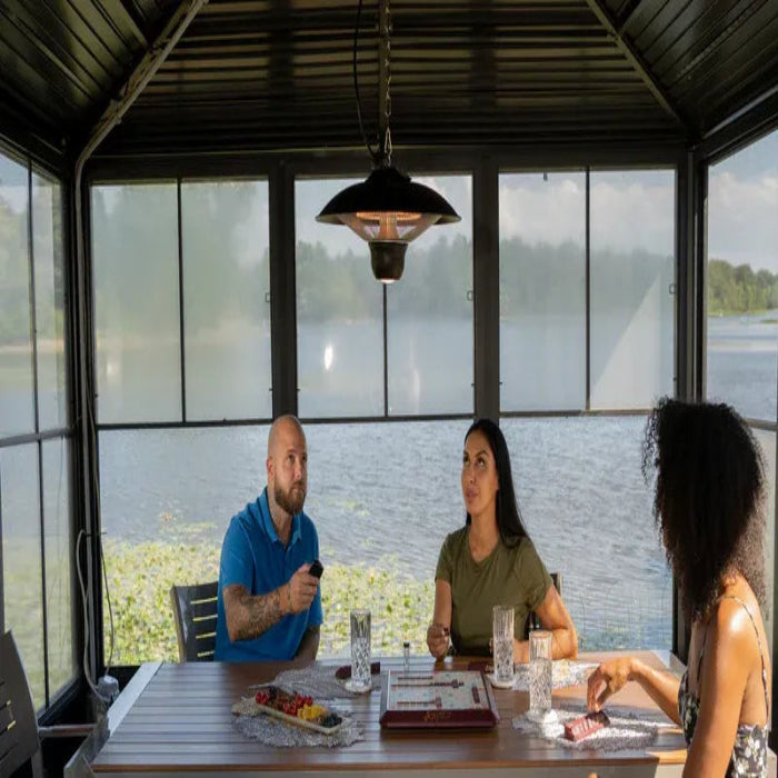 Three people sitting at a table by a large window with a view of water.